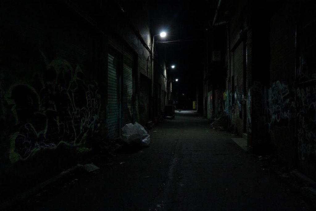 Ruelle urbaine déserte éclairée par des lampadaires