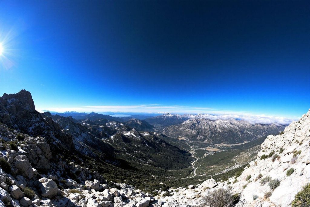 Vue large sur des montagnes rocheuses avec vallée et route