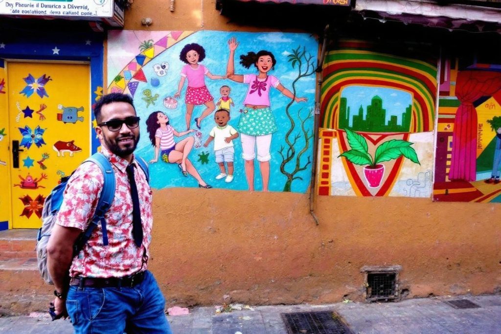 Homme devant une fresque murale représentant des personnages riants