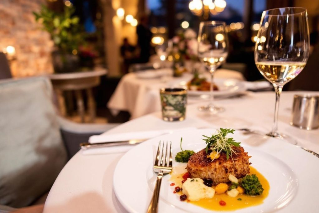 Plat raffiné avec sauce jaune, accompagné de vin blanc