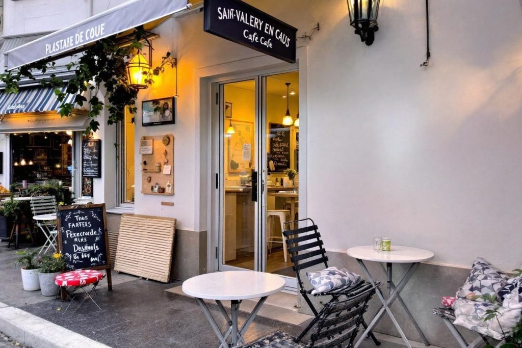 Terrasse de café chaleureuse avec tables et chaises blanches