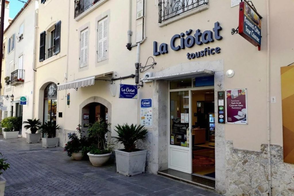Façade blanche d'un office de tourisme avec des plantes