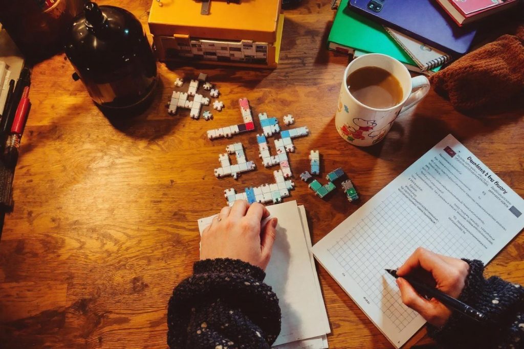 Table en bois avec puzzles, tasse à café et mains travaillant
