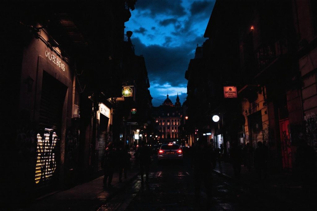 Rue sombre avec voiture, éclairages et ciel bleu nocturne