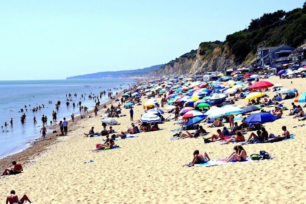 Plage bondée avec parasols colorés et falaises en arrière-plan