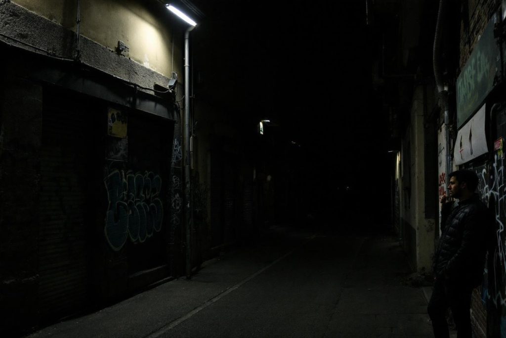 Passage étroit faiblement éclairé avec murs couverts de tags