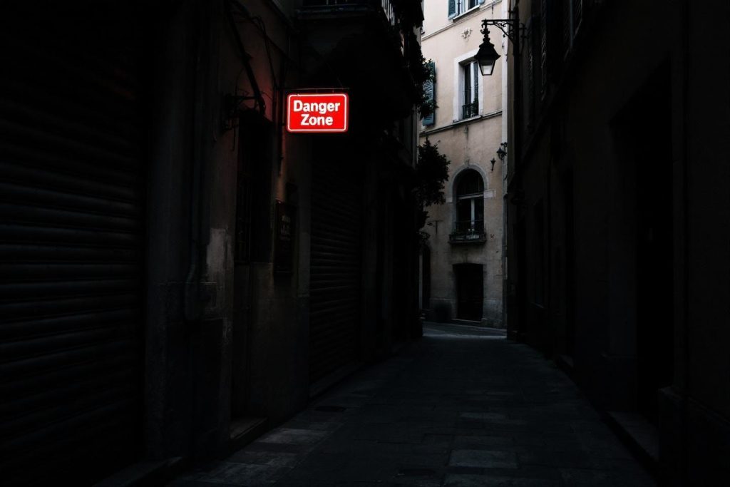 Panneau rouge "Danger Zone" dans une ruelle étroite et sombre