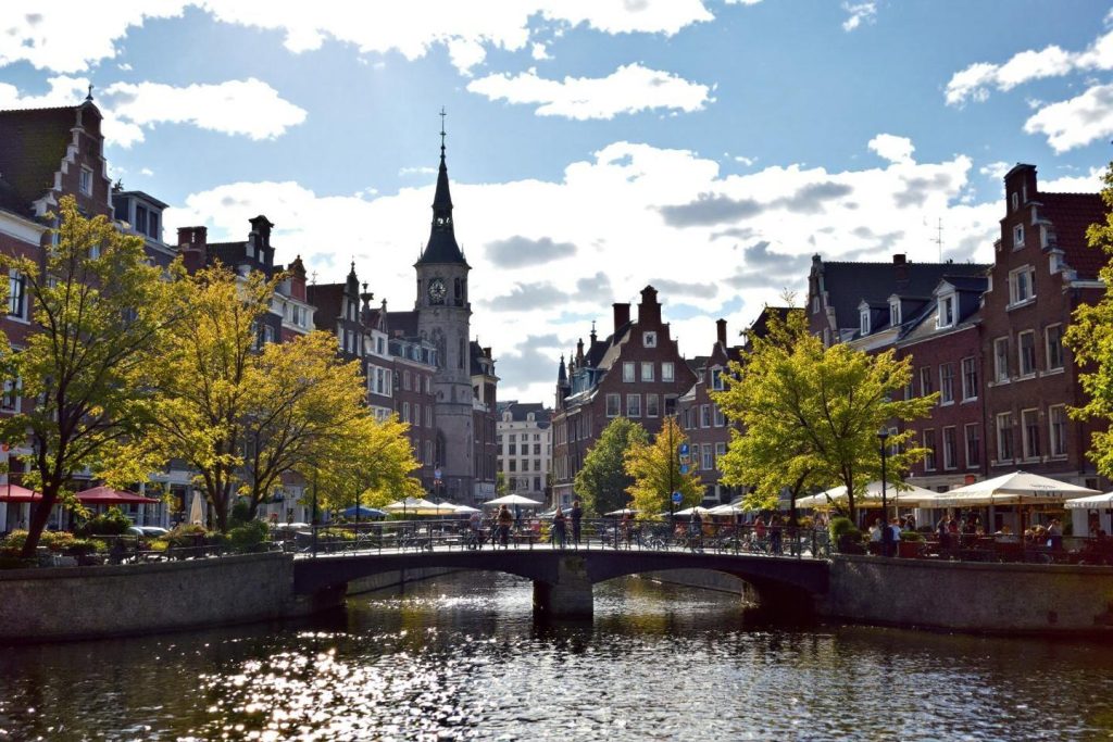 Pont sur un canal avec bâtiments historiques et arbres verdoyants