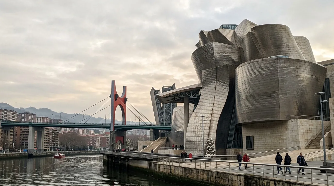 Musée contemporain avec pont rouge et visiteurs sur promenade.